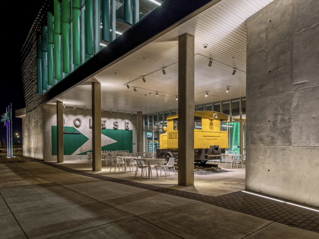 A Gem Shines Through | Dolese Bros headquarters | The outdoor patio features a historic steam locomotive and vintage signage highlighted with LSI 1800-lumen, 40-deg flood and 98-CRI luminaires