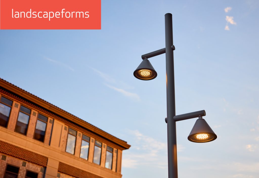 A streetlight from the Landscape Form's Moment line on the street with a building on the background | Moment line by Landscape Forms