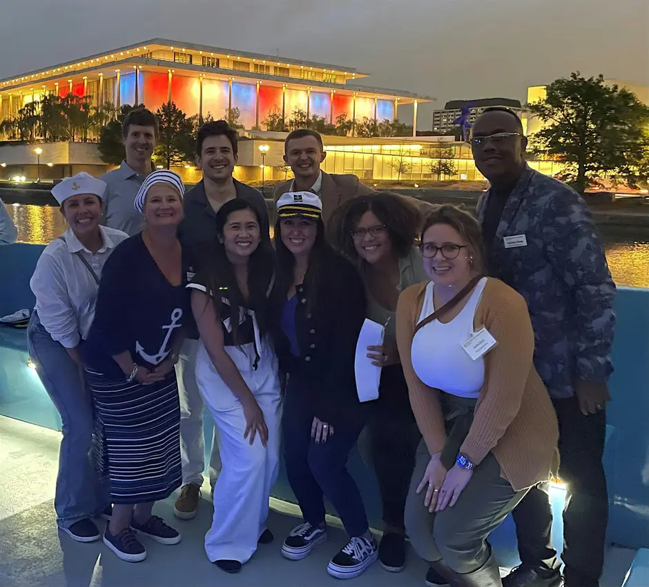 IES DC Fall 2026 Sunset Cruise - The Great Ocean Adventure! 1 IES DC Section | People smiling and posing with the Georgetown Washington Harbor dock behind