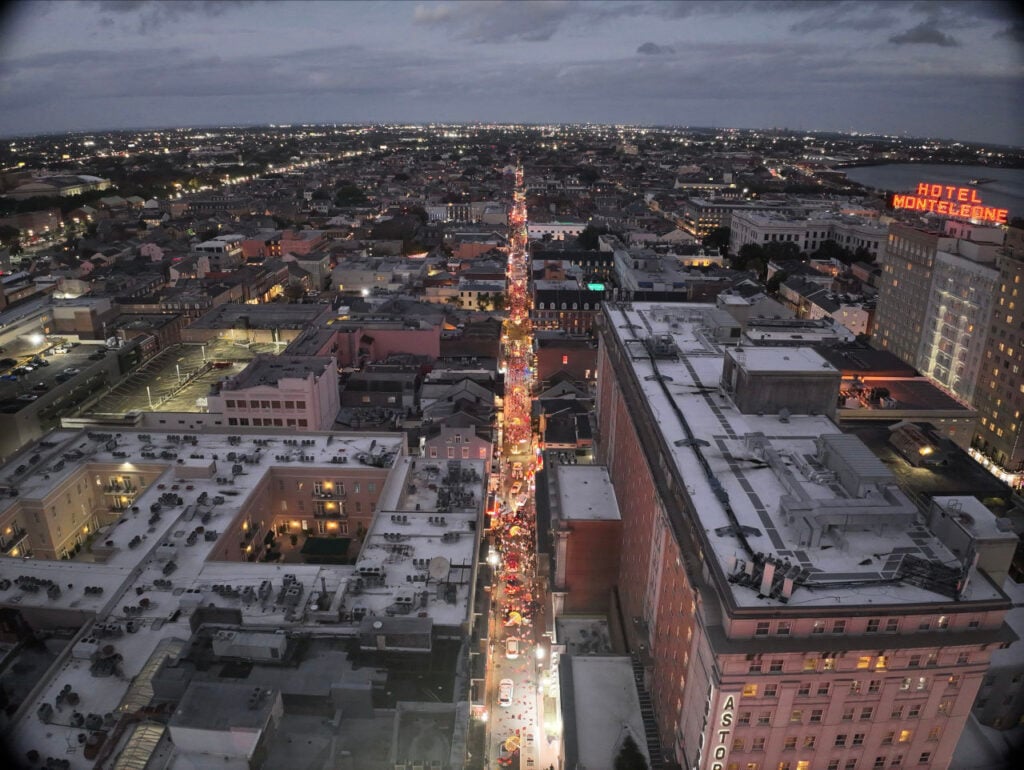 A Quarter for Your Thoughts | Weaving remembrance, culture, and community into the fabric of New Orleans | Suspended between 21 buildings and across three blocks, the installation creates a continuous illuminated plane. Photo: Charles Sterling with Zepher Drones