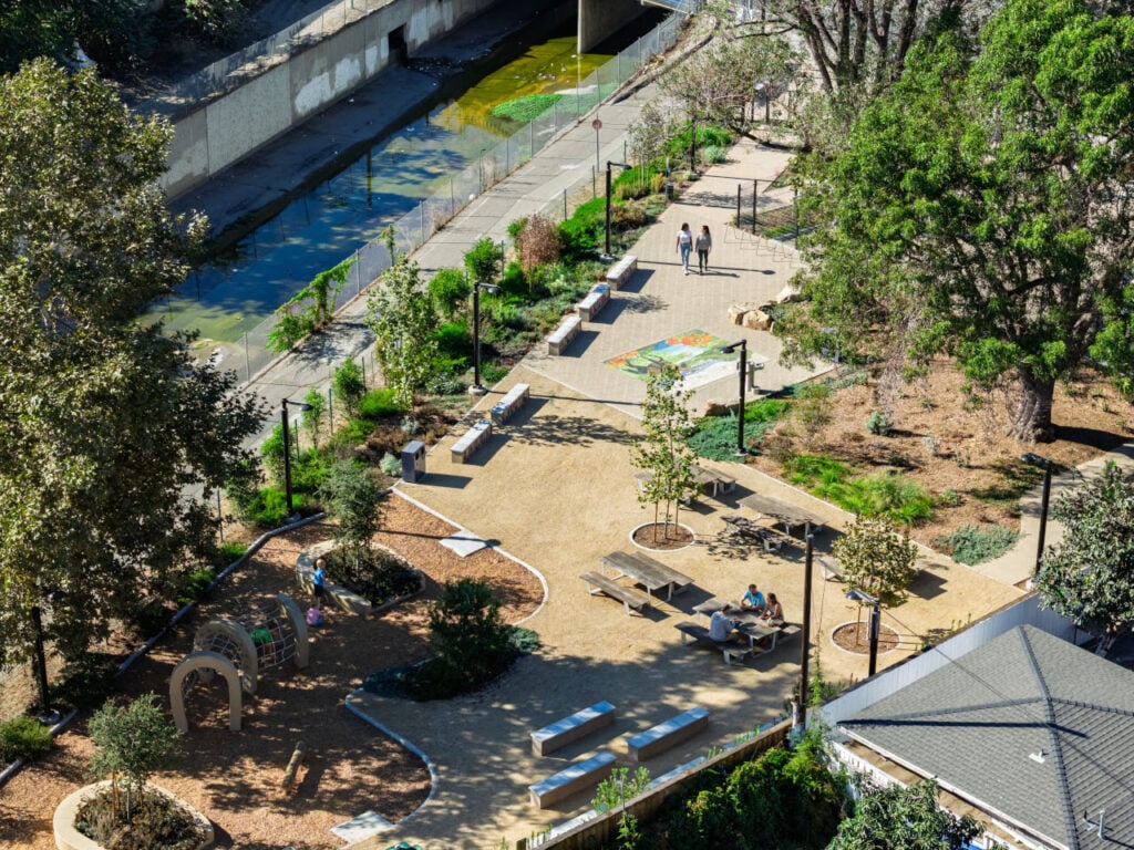 Alondra Gateway Park transforms a half-acre lot into a vibrant community destination | Sky view of two people walking at the park and a group of three people sitting on a table