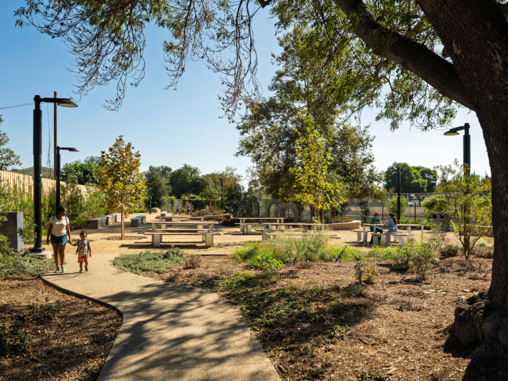 Alondra Gateway Park transforms a half-acre lot into a vibrant community destination | A young woman walking with her child and two young people sitting at a table