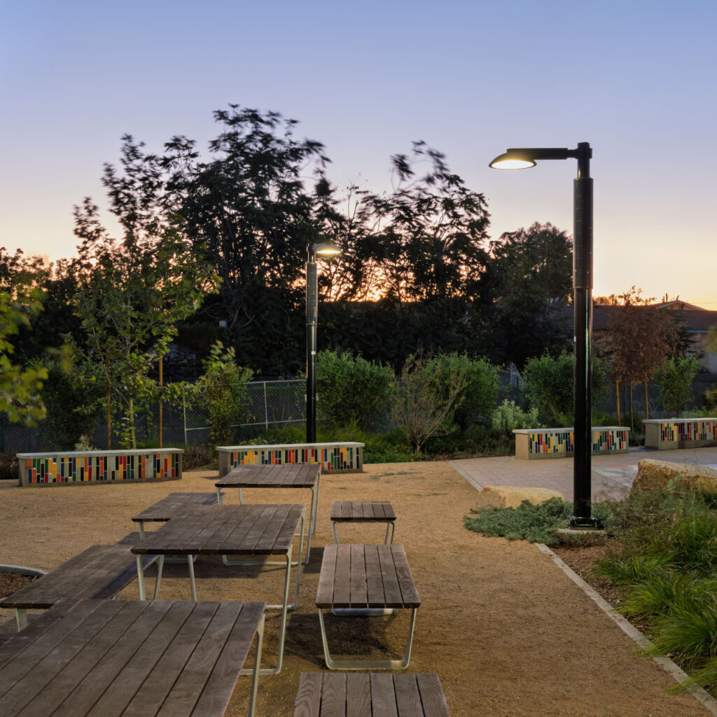 Alondra Gateway Park transforms a half-acre lot into a vibrant community destination | Alondra Gateway Park at dusk featuring light poles