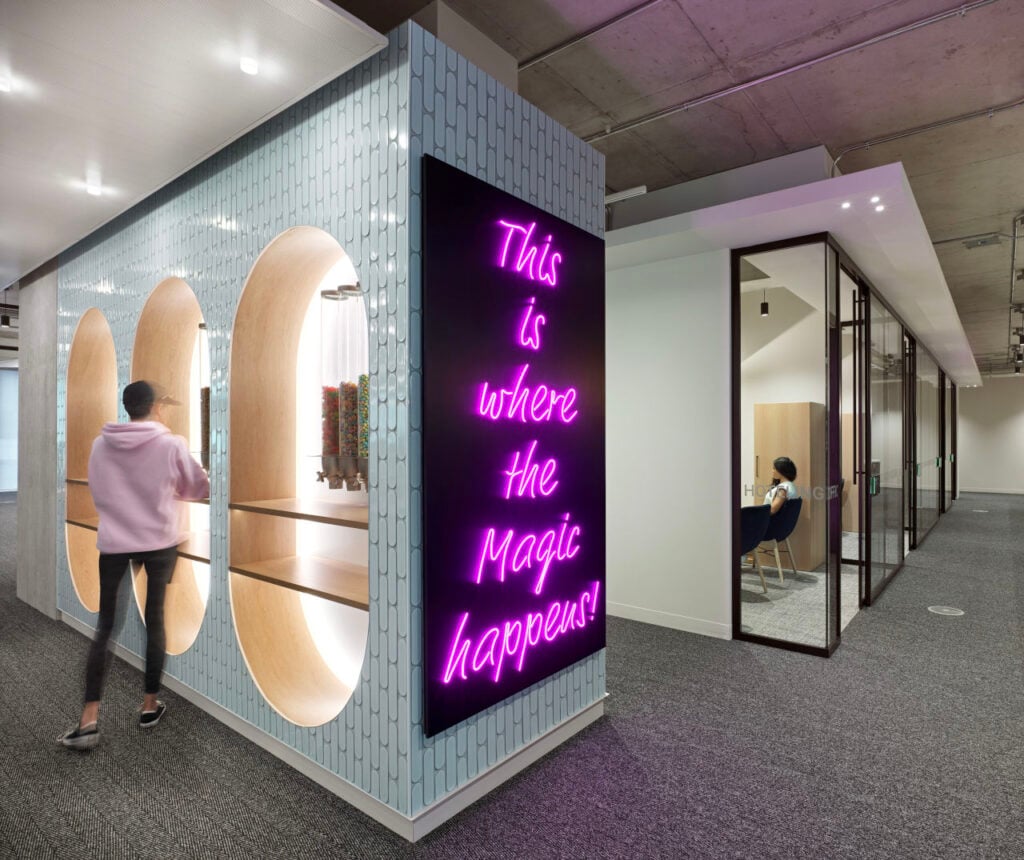 Hospitality in the Workplace 3 Hospitality in the Workplace | Pill-shaped millwork elements are backlit with cove lighting